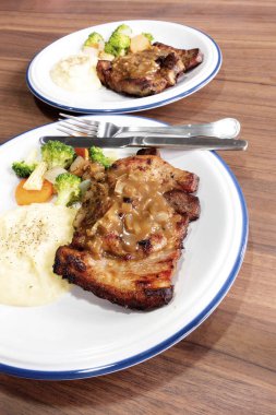 Ahşap arka plan üzerinde sebze ile domuz eti biftek