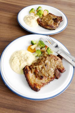 Ahşap arka plan üzerinde sebze ile domuz eti biftek