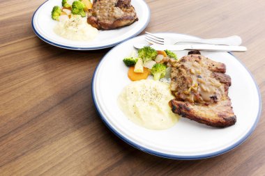 Ahşap arka plan üzerinde sebze ile domuz eti biftek