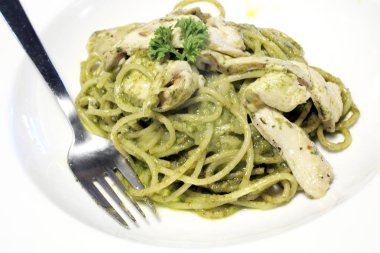beyaz zemin üzerine pesto soslu spagetti