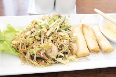 Kızarmış deniz ürünleri erişte beyaz plaka üzerinde