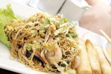 Kızarmış deniz ürünleri erişte beyaz plaka üzerinde