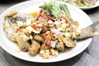 Balık ve beyaz plaka üzerinde otlar