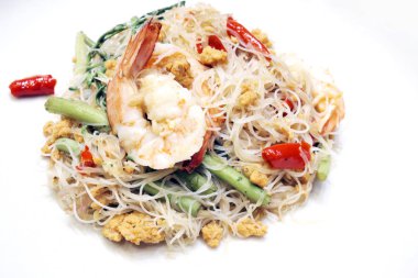 Kızarmış deniz ürünleri erişte beyaz plaka üzerinde