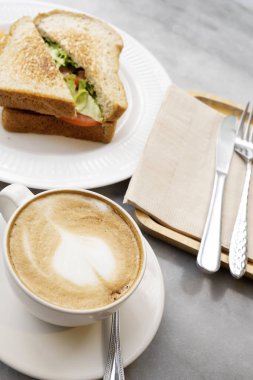 Mermer masada sıcak latte kahve ve sandviçler