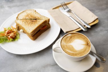 Mermer masada sıcak latte kahve ve sandviçler