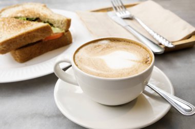 Mermer masada sıcak latte kahve ve sandviçler