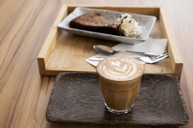 Ahşap bir masa üzerinde sıcak latte