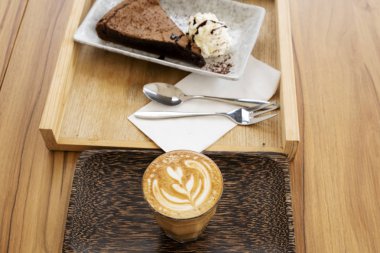 Ahşap bir masa üzerinde sıcak latte