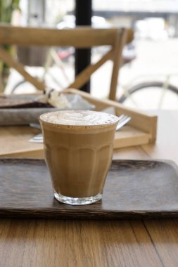 Ahşap bir masa üzerinde sıcak latte