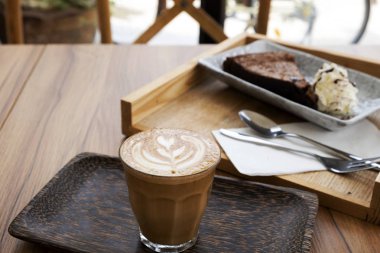 Ahşap bir masa üzerinde sıcak latte