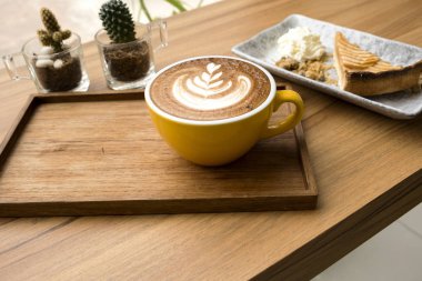 Ahşap bir masada sıcak latte ve elma tart