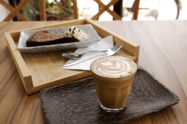 Ahşap bir masa üzerinde sıcak latte