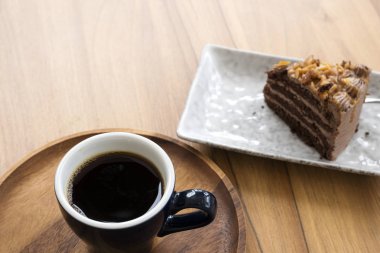 Ahşap bir masada sıcak kahve ve şekerleme kek