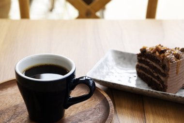 Ahşap bir masada sıcak kahve ve şekerleme kek