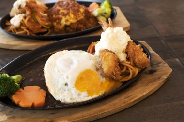 Ahşap bir masada kızarmış karides ve Japon tarzı biftek.