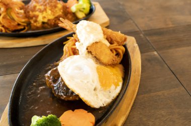 Ahşap bir masada kızarmış karides ve Japon tarzı biftek.