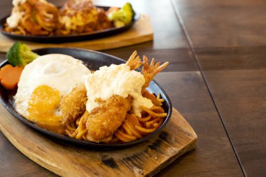 Ahşap bir masada kızarmış karides ve Japon tarzı biftek.