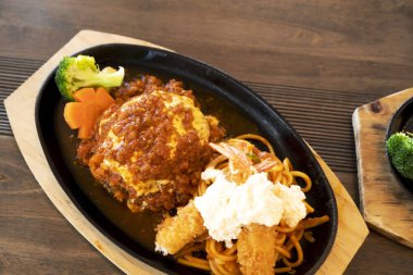 Ahşap bir masada kızarmış karides ve Japon tarzı biftek.