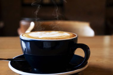 Ahşap yemek masasında sıcak latte