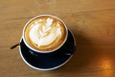 Ahşap yemek masasında sıcak latte