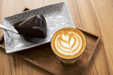 Sıcak Latte, Latte Sanat Desen, Ahşap bir masa üzerinde kek ile güzel