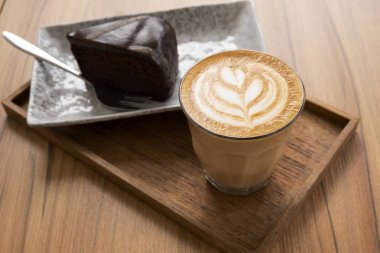 Sıcak Latte, Latte Sanat Desen, Ahşap bir masa üzerinde kek ile güzel