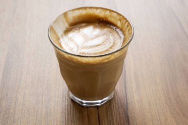 Ahşap bir masa üzerinde sıcak latte