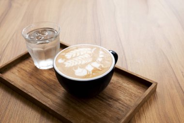 Ahşap masada güzel latte sanat ile sıcak latte