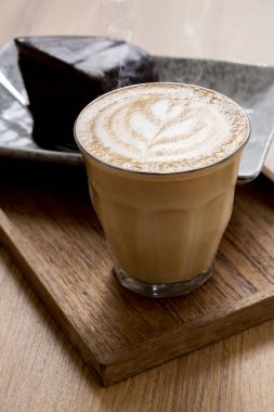 Sıcak Latte, Latte Sanat Desen, Ahşap bir masa üzerinde kek ile güzel
