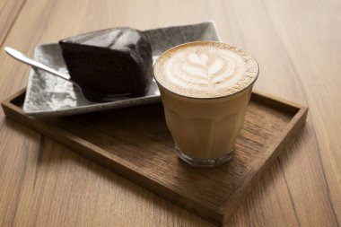 Sıcak Latte, Latte Sanat Desen, Ahşap bir masa üzerinde kek ile güzel