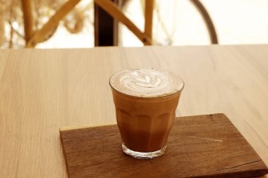 Ahşap zeminler üzerinde sıcak latte ve güzel sanat latte