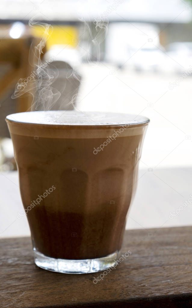 Hot latte and beautiful art latte on wooden floors
