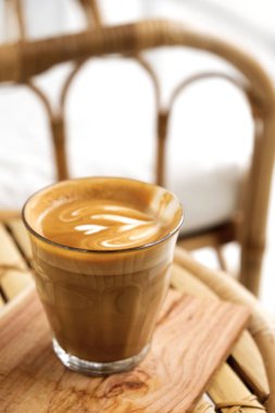 Masada bir bardak sıcak latte ve sanat latte
