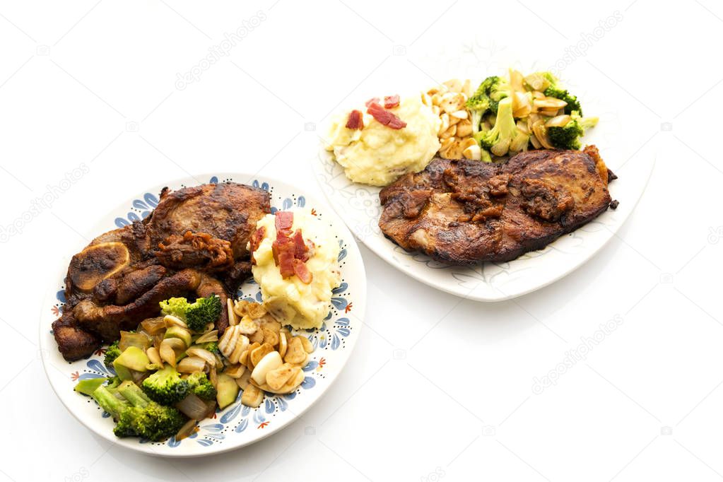 Pork steak with vegetables on a white background