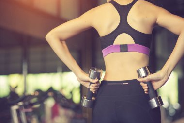 Genç fitness kadın, egzersiz dumbbells ile yürütmek