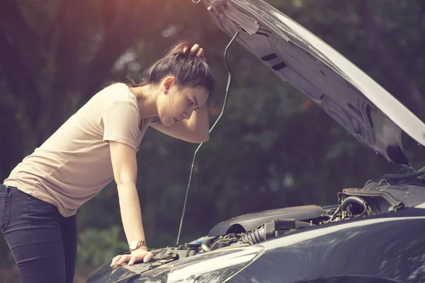 Women spection She opened the hood Broken car on the side See engines that are damaged or not.Vintage color