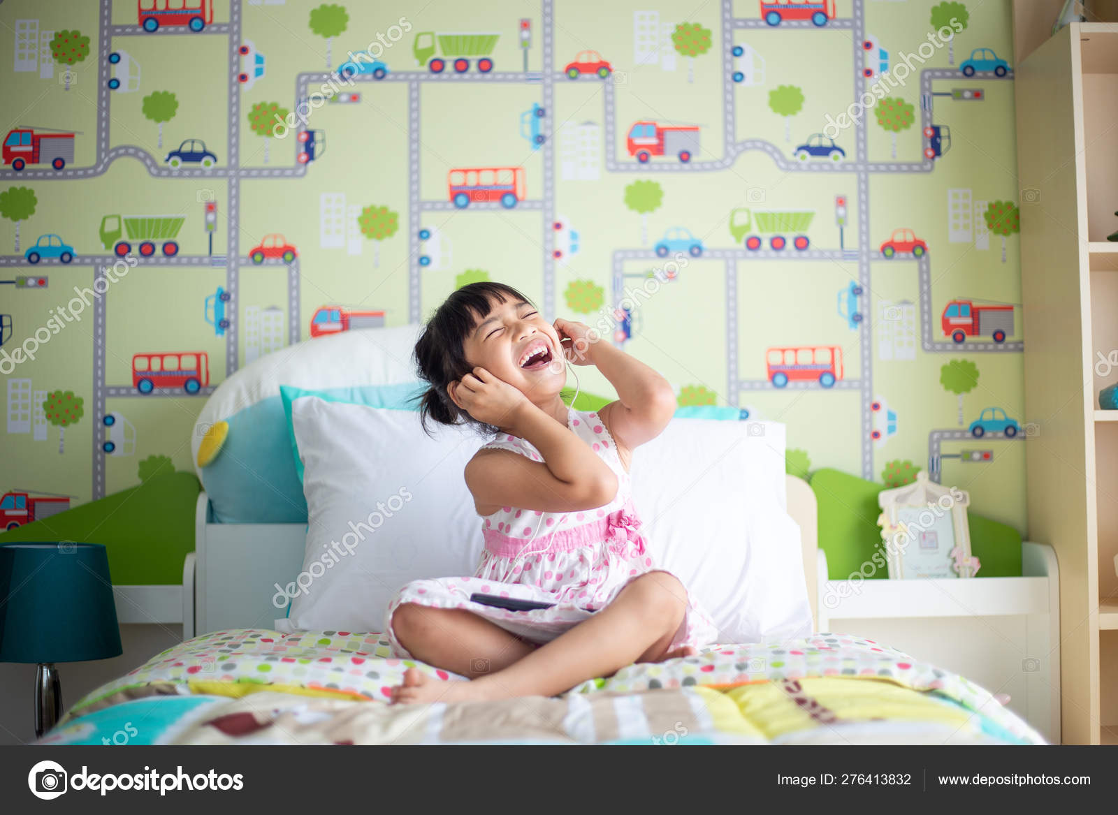 Asian children using headphone for listen music by smartphone on