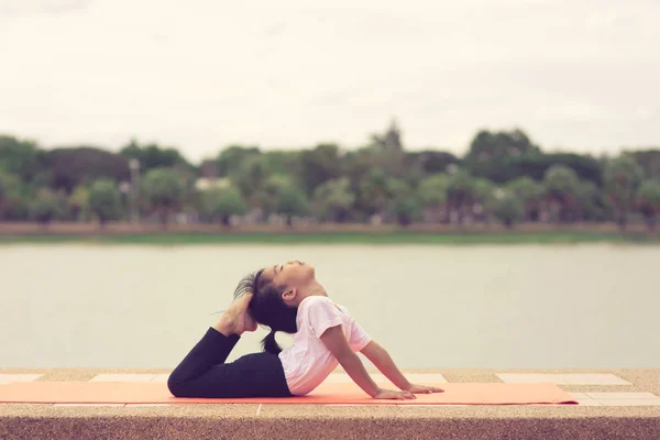 Trochę ładny Asian Dziewczyna praktykujący Joga Pose na a mat w Park, on — Zdjęcie stockowe