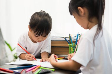 Covid-19 Coronavirus ve evden öğrenme, ev okulu çocuk konsepti. Küçük çocuklar evde bilgisayarla online öğrenim görüyorlar..