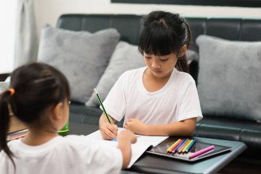 Covid-19 Coronavirus ve evden öğrenme, ev okulu çocuk konsepti. Küçük çocuklar evde bilgisayarla online öğrenim görüyorlar..