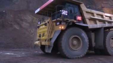 Büyük damperli kamyon yüklü cevher yükleme bırakır.