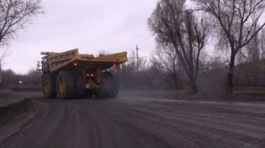 İki büyük kamyon taş ocağına gidiyor.