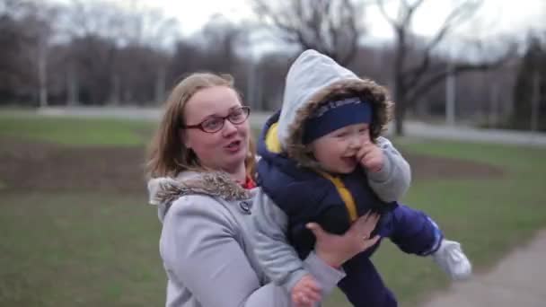 ママは彼女の腕の中で息子を囲む 子供は幸せで笑う — ストック動画