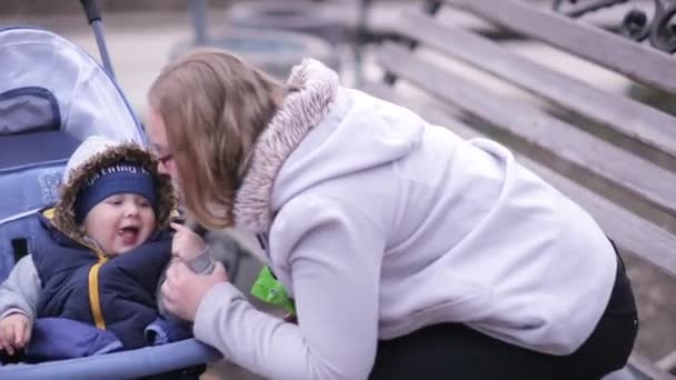 Een Baby Een Kinderwagen Eet Koekjes Lacht Terwijl Naar Mama — Stockvideo
