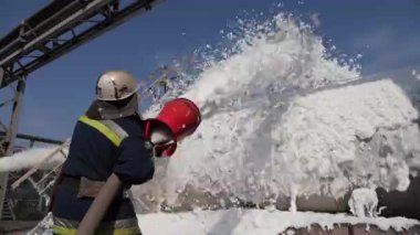 Petrol ürünlerine dayalı yangın söndürme. İtfaiyeci köpük ile bir yangın söndürür
