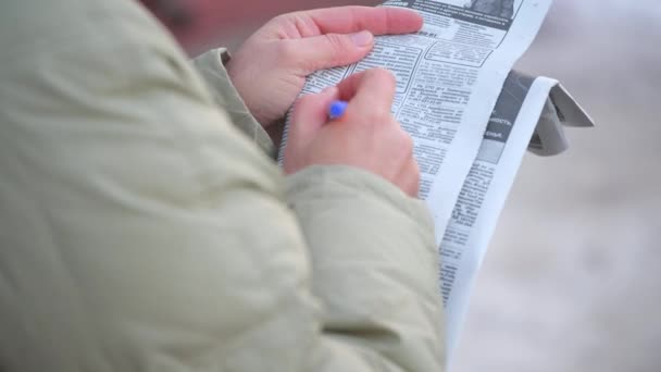 Närbild Man Håller Tidning Sina Händer Och Noterar Med Penna — Stockvideo