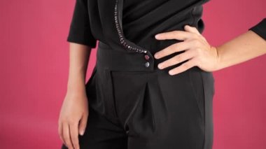 Close. Pembe bir arka plan üzerinde siyah tulum kız stüdyoda poz