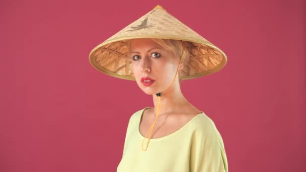 麦わら帽子とピンクの背景にポーズ黄色のドレスで美しいヨーロッパの女の子 — ストック動画