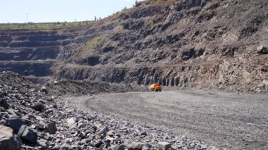 Su makinesi demir cevheri ocağında çalışıyor. Ağır bir kamyon yolu demir cevheri ocağında suyla dolduruyor. Toz temizleme, çevrenin korunması. Yolun tozdan sulanması